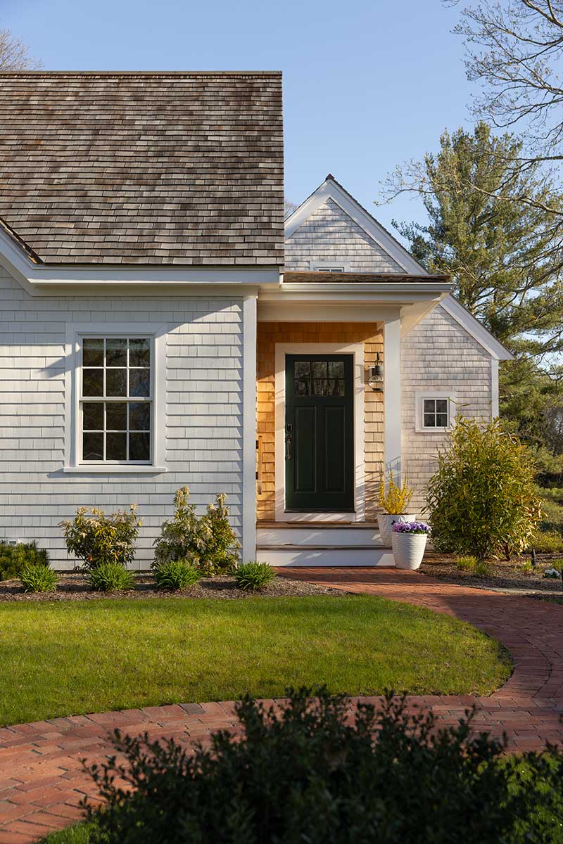 The front door of a traditional home in Duxbury, MA, featuring Marvin Elevate Double Hung and Elevate Awning windows.