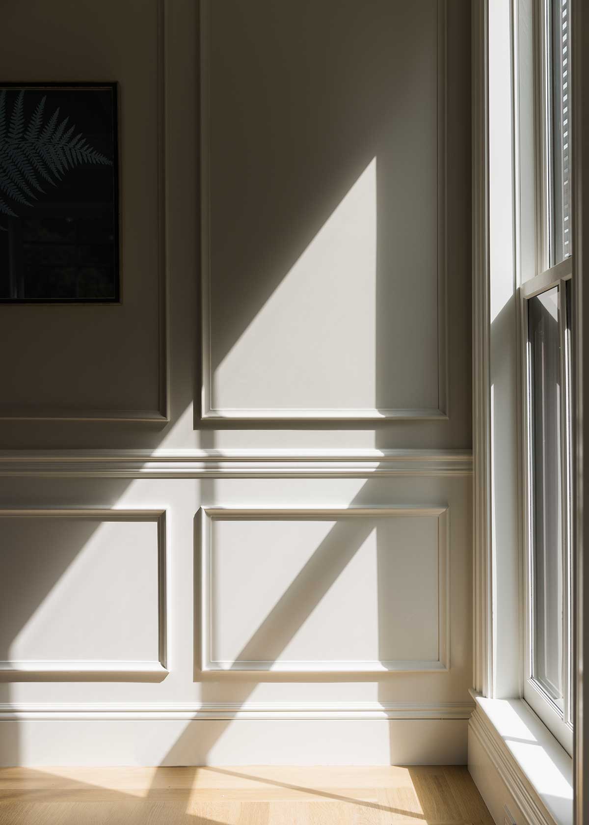 Light coming in through Marvin Ultimate Double Hung G2 windows, casting a shadow on a historic home's wall.