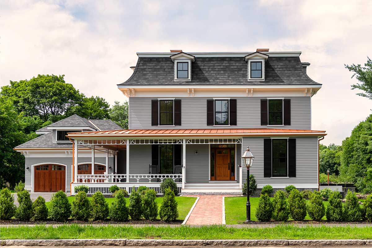 The exterior of a remodeled Second Empire home, featuring Marvin Ultimate Double Hung G2 windows.